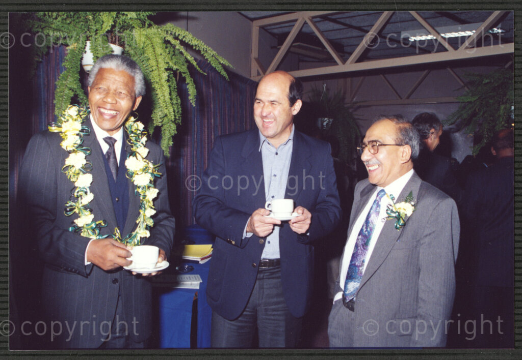Turfloop Campus, University of the North, Mankweng, Northern Transvaal, South Africa, 19920425. PHOTO: ANC Archives.

Nelson Mandela, the president of the African National Congress (ANC) (left), in a celebratory mood and wearing a lei of flowers around his neck, stands with an unidentified man (centre), and Kadar Asmal, a member of the council of the University of the North, at a celebratory function on the day of his installation as chancellor of the University of the North (now the University of Limpopo), 25 April 1992, Turfloop Campus, Mankweng, Northern Transvaal (now Limpopo), South Africa.