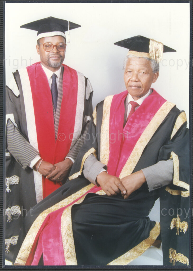 Turfloop Campus, University of the North, Mankweng, Northern Transvaal, South Africa, 19920425. PHOTO: ANC Archives.

A formal photographic portrait of Nelson Mandela, the president of the African National Congress (ANC) (right), and Professor Noel Chabani Manganyi (left), wearing full academic regalia on the occasion of their installation as chancellor and vice chancellor of the University of the North respectively, 25 April 1992, Turfloop Campus, University of the North (now the University of Limpopo), Mankweng, Northern Transvaal (now Limpopo), South Africa.