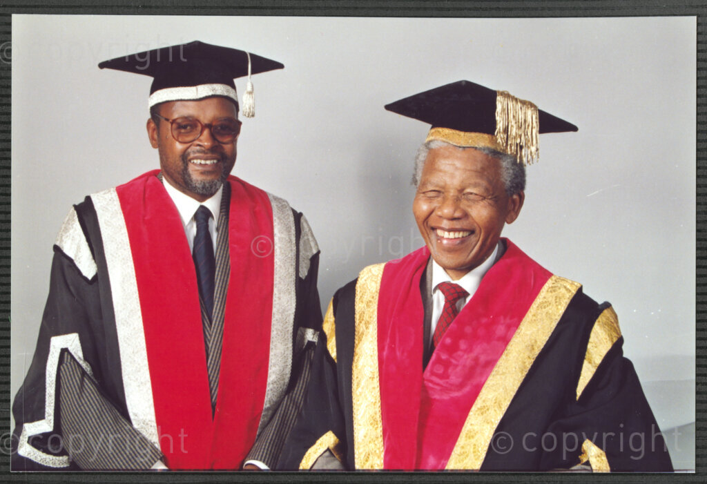 Turfloop Campus, University of the North, Mankweng, Northern Transvaal, South Africa, 19920425. PHOTO: ANC Archives.

A formal photographic portrait of Nelson Mandela, the president of the African National Congress (ANC) (right), and Professor Noel Chabani Manganyi (left), wearing full academic regalia on the occasion of their installation as chancellor and vice chancellor of the University of the North respectively, 25 April 1992, Turfloop Campus, University of the North (now the University of Limpopo), Mankweng, Northern Transvaal (now Limpopo), South Africa.