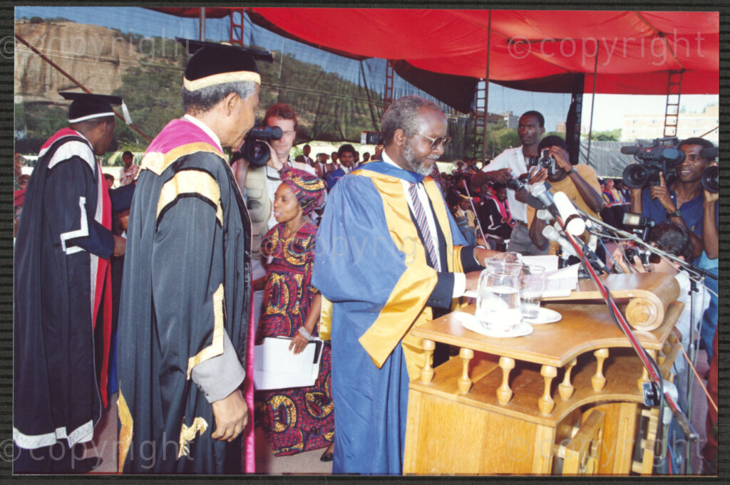 Turfloop Campus, University of the North, Mankweng, Northern Transvaal, South Africa, 19920425. PHOTO: ANC Archives.

Professor Walter Kamba, the chairman of the International Association of Universities and former vice chancellor of the University of Zimbabwe (right), stands beside Nelson Mandela, the president of the African National Congress (ANC) (left), during Mandela's installation as chancellor of the University of the North, 25 April 1992, Turfloop Campus of the University of the North (now the University of Limpopo), Mankweng, Northern Transvaal (now Limpopo), South Africa.