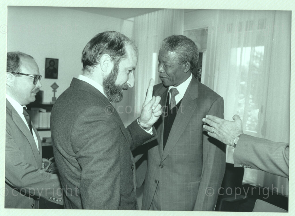 Geneva Ecumenical Centre, Geneva, Switzerland, 19900601. PHOTO: ANC Archives.

Standing amongst a group of men, recently elected Deputy President of the African National Congress (ANC) Nelson Mandela (right) greets author Ion Bria (back left) at the Geneva Ecumenical Centre, Switzerland when the Mandela couple visit staff, officials and representatives of the World Council of Churches (WCC) during Nelson Mandela's official visit to Switzerland, 4-9 June 1990. During the visit, barely a few months after his release from prison, Nelson Mandela expresses his gratitude to the church for its support of the anti-apartheid struggle.