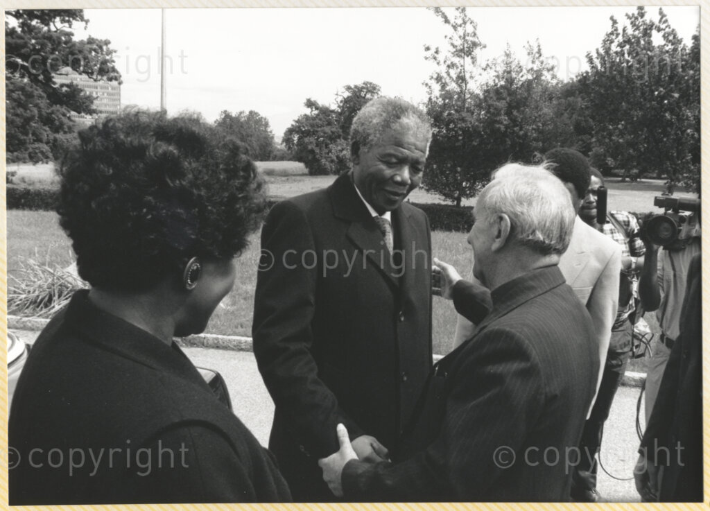 Geneva Ecumenical Centre, Geneva, Switzerland, 19900601. PHOTO: ANC Archives.

Winnie Madikizela- Mandela with her back to the camera and recently elected Deputy President of the African National Congress (ANC) Nelson Mandela greets Secretary General of the World Council of Churches Emilio Castro in the garden of the Geneva Ecumenical Centre, Switzerland when the Mandela couple visit staff, officials and representatives of the (WCC) during Nelson Mandela's official visit to Switzerland, 4-9 June 1990. During the visit, barely a few months after his release from prison, Nelson Mandela expresses his gratitude to the church for its support of the anti-apartheid struggle.