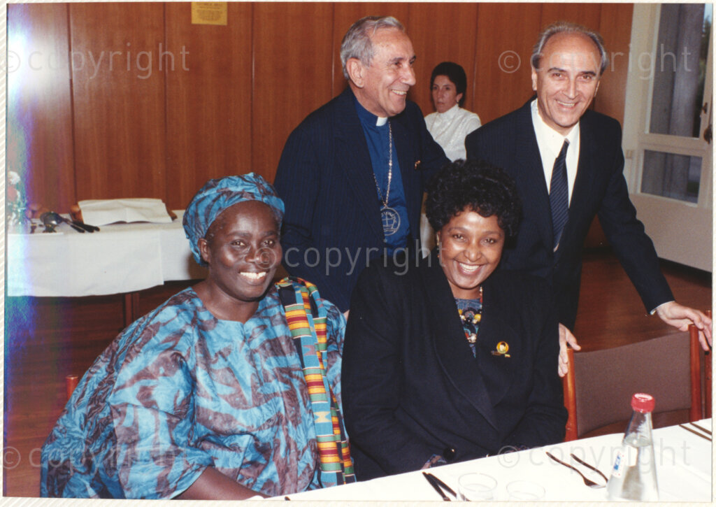 Geneva Ecumenical Centre, Geneva, Switzerland, 19900601. PHOTO: ANC Archives.

A few months after his release from prison, newly elected deputy president of the African National Congress (ANC) Nelson Mandela and his wife, Winnie Madikizela-Mandela pay an official visit to Switzerland, 4-9 June 1990. Shortly after his arrival in Geneva, he visits staff and officials and representatives of the World Council of Churches (WCC) at the Geneva Ecumenical Centre. Seated at a table Ghanaian Methodist theologian Mercy Amba Oduyoye (left), Winnie Madikizela-Mandela (right), General Secretary of the WCC Churches Emilio Castro (standing left) and an unknown male (standing right).