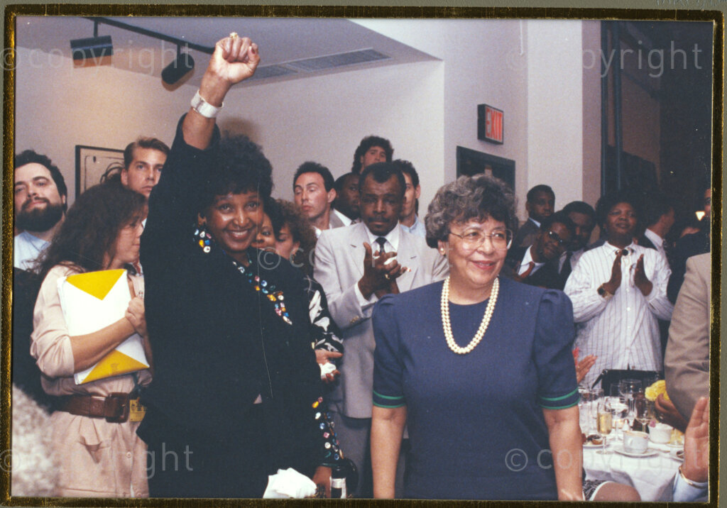 New York, New York State, United States of America, 19900601. PHOTO: ANC Archives.

In 1990, Nelson Mandela and his wife, Winnie Mandela, visit the city of New York from 20 to 23 June. This is the start of a 14-nations Freedom Tour, just 4 months after Mandela's release from jail. Winnie, seen here on the left, is in joyous mood as she raises the fist of solidarity. Beside her is her hostess, Joyce Dinkins, wife of New York Mayor, David Dinkins.