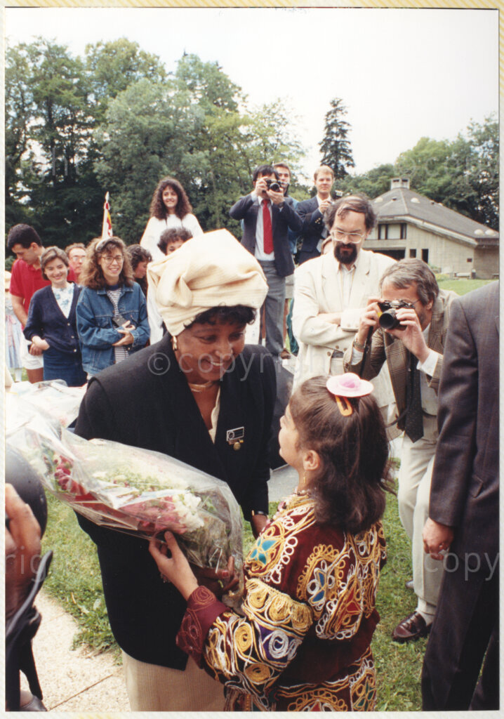 John Knox International Reform Centre, Geneva, Switzerland, 19900609. PHOTO: ANC Archives.

Winnie Madikizela- Mandela (front centre) surrounded by unidentified guests and the media bends down to accept a bouquet of flowers from a young girl in the gardens of the John Knox International Reform Centre, Geneva, Switzerland during the recently appointed Deputy President of the African National Congress (ANC) Nelson Mandela's official visit to Switzerland, 4-9 June 1990.