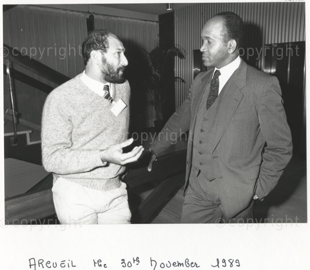 Arcueil, Val-de-Marne, Paris, Île-de-France, France, 19891130. PHOTO: ANC Archives: African National Congress comrade Trevor Manuel (left) chats with a Cuban representative (right) at a gathering of anti-apartheid activists in Arcueil, France on 30 November 1989 at which a commemorative plaque for Dulcie September is unveiled. Dulcie September, a South African anti-apartheid activist and ANC Chief Representative in France, Switzerland and Luxembourg, was assassinated outside the ANC's Paris office at 28 Rue des Petites-Ecuries last year on 29 March 1988.