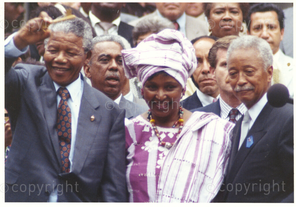 New York, New York State, United States of America, 19900620. PHOTO: ANC Archives.

Nelson Mandela and his wife, Winnie, wearing traditional African attire, are on a 14-nation Freedom Tour in June 1990, just four months after Mandela's release from prison. In New York, in the United States of America,Mayor David N. Dinkins, (right) and his wife, Joyce, are the Mandela's hosts. Dinkins is the first black mayor of New York City. Mandela is overwhelmed by the level of enthusiasm emanating from the tens of thousands of ordinary people, black and white. He responds with a typically warm and enthusiastic solidarity salute.