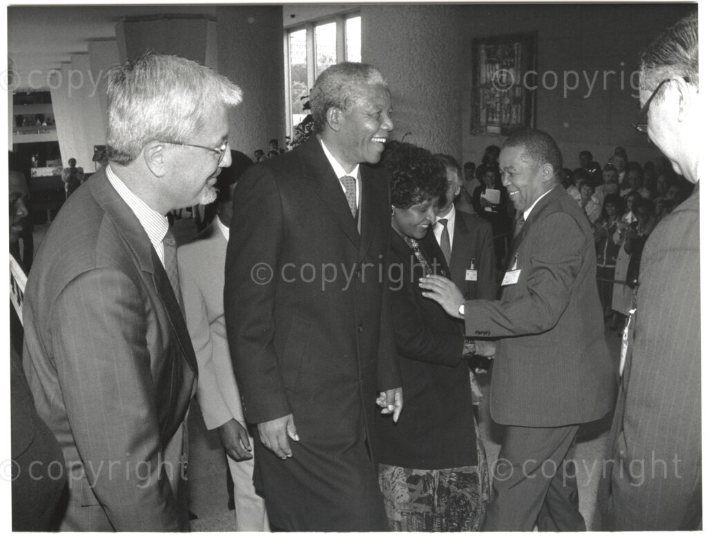 International Labour Organisation , Geneva, Switzerland, 19900608. PHOTO: ANC Archives.

Barely four months after his release from 27 years in prison the deputy president of the African National Congress (ANC), Nelson Mandela and his spouse Winnie Madikizela-Mandela embark on an official visit to Switzerland, 4-9 June 1990. Standing in a group(left to right) the director-general of the International Labour Organisation (ILO) Michel Hansenne, Nelson Mandela and Winnie Madikizela, either before or after Nelson Mandela's address to the 77th Session of the International Labour Conference (ILC) where he expresses his gratitude for the support received from the ILO and urges the international community to persist in their demands that all political prisoners must be released, political trials ended, exiles returned, repressive legislation repealed, and the state of emergency ended in its entirety.