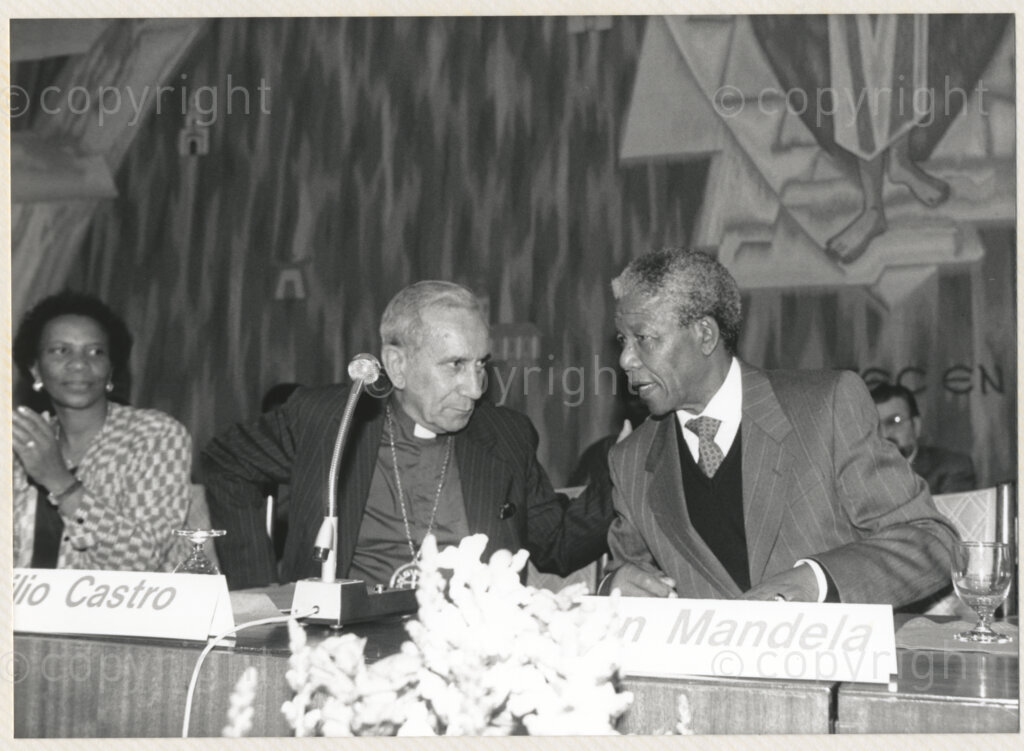 Geneva Ecumenical Centre, Geneva, Switzerland, 19900601. PHOTO: ANC Archives.

Seated at a table Deputy General Secretary South African Council of Churches Brigalia Bam (left), recently elected Deputy President of the African National Congress (ANC), Nelson Mandela (right) and World Council of Churches (WCC) Emilio Castro at the Geneva Ecumenical Centre, Switzerland when the Mandela couple visit staff, officials and representatives of the World Council of Churches (WCC) during Nelson Mandela's official visit to Switzerland, 4-9 June 1990. During the visit barely a few months after his release from prison, Nelson Mandela expresses his gratitude to the church for its support of the anti-apartheid struggle.