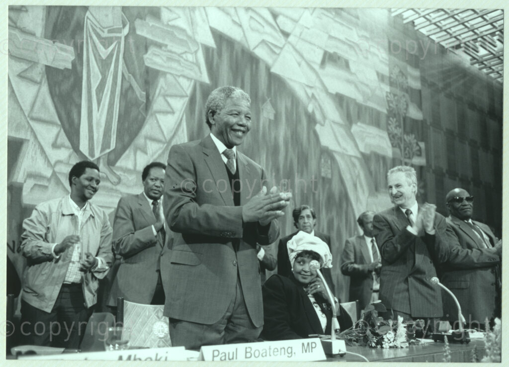 Geneva Ecumenical Centre, Geneva, Switzerland, 19900601. PHOTO: ANC Archives.

A group of unidentified officials and recently elected Deputy President of the African National Congress (ANC), Nelson Mandela (front left) at the main table on stage applaud while Winnie Madikizela-Mandela remains seated at the Geneva Ecumenical Centre, Switzerland when the Mandela couple visit staff, officials and representatives of the World Council of Churches (WCC) during Nelson Mandela's official visit to Switzerland, 4-9 June 1990. During the visit barely a few months after his release from prison, Nelson Mandela expresses his gratitude to the church for its support of the anti-apartheid struggle.