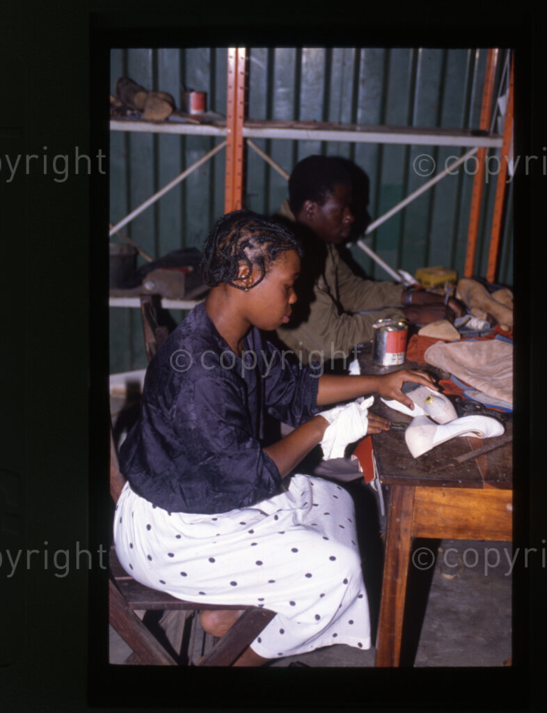 Leather workshop and shoe factory and students fitting shoes, Mazimbu (SOMAFCO), Tanzania, 1990
