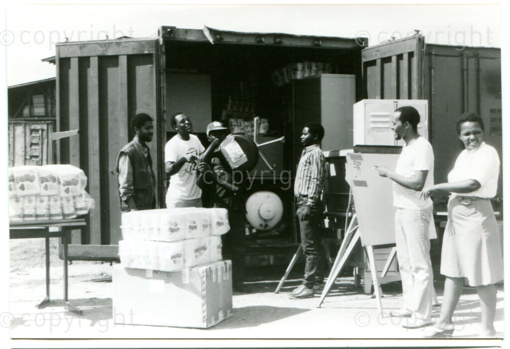 Arrival of a container with solidarity goods from The Netherlands in Mazimbu, Tanzania, Spring 1988; right (with white shirt): projects officer Titus Khotsoe. Photo: Eli Weinberg Photo Lab.