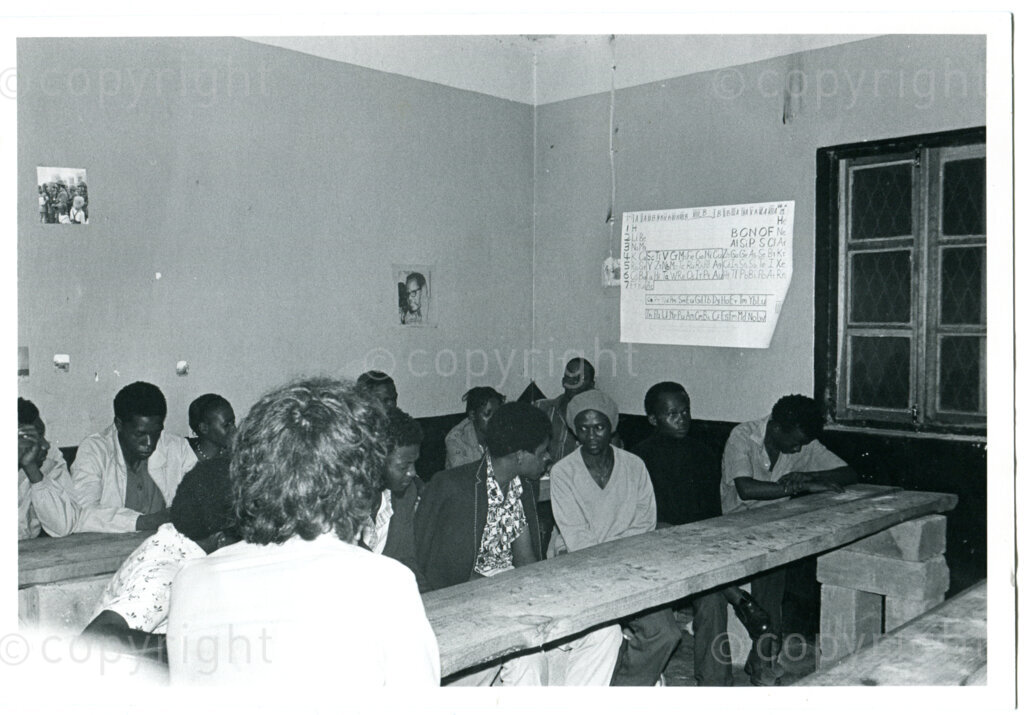 Dutch AAM representative Rob Duyker (in front) discusses with ANC students in one of the old classrooms, Mazimbu, Tanzania, 22 April 1979. Photographer: Spencer Hodges.