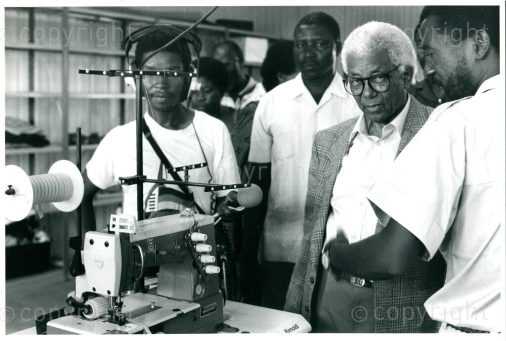 Visit of ANC-leader Walter Sisulu (right, with classes) to the garment factory in the ANC Development Centre Dakawa, Tanzania, February 1990. Photo: Eli Weinberg Photo Lab.