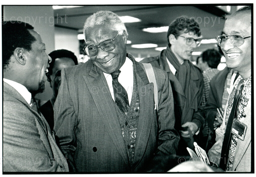 Honorary doctor Govan Mbeki visits the University of Amsterdam, 28 September 1990: arrival at Schiphol airport; right: ANC-representative Kumar Sanjay. Photographer: Henk Thomas.