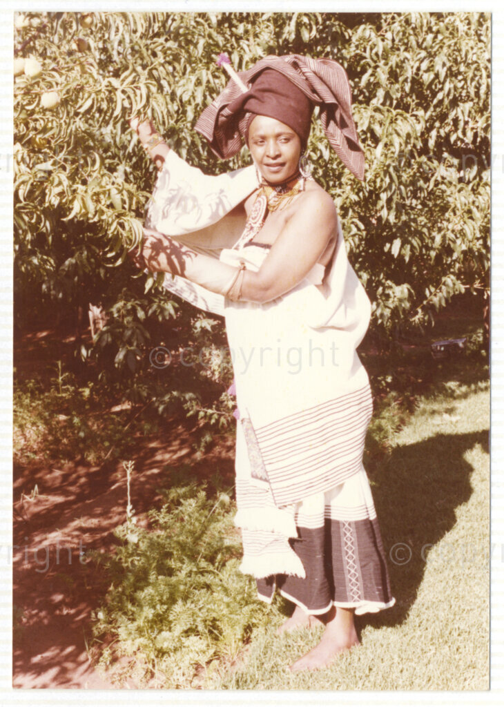 A portrait of Winnie Mandela wearing traditional Xhosa attire, circa 1980. She was one of the most important icons of the struggle against apartheid in South Africa and wore traditional outfits and accessories during a time when donning cultural wear was seen as a political taboo. The outfit reflects the cultural heritage of her birthplace, Bizana, a rural town in the Transkei in the Eastern Cape.
