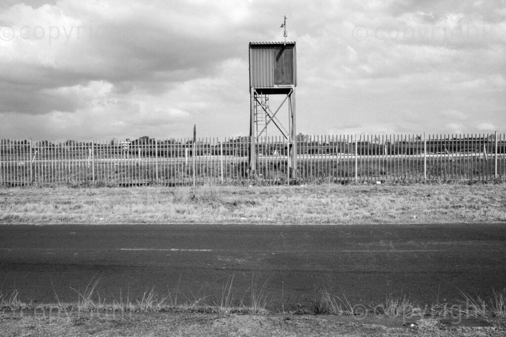 Some aspects of the city of Pietermaritzburg in KwaZulu-Natal, South Africa. Pietermaritzburg is one of the oldest cities of South Africa, the city fathers like to call it the City of Choice. The photographer John Robinson ended up back in the city when he had to leave Johannesburg while walking into the mist seeking out a dignified and beautiful place.

Pietermaritzburg is not a perfect city by any standards, it is located in a geographical bowl straddling the Msunduzi River, it is a juxtaposition of many people and things. A city that many people just pass on their way to and from the cities of Durban and Johannesburg on the bisecting N3 highway.

All these spaces are public or easily accessible to all the people of Pietermaritzburg. Though many people in this city prefer to live out their lives behind their own high walls or in office parks and malls that have visible security. Non the less these spaces remain as evidence of human intervention. 2023, Pietermaritzburg, KwaZulu-Natal, South Africa.