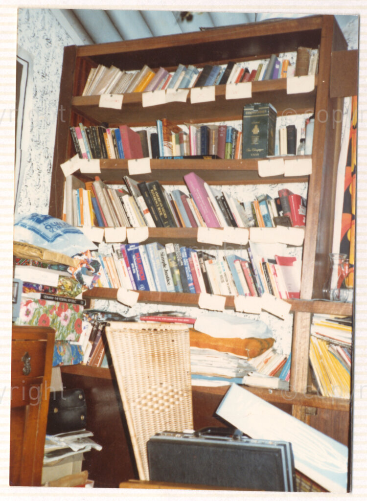An overflowing bookcase in the living room of what is thought to be Winnie Mandela's house in Brandfort, circa 1980. Despite the disarray, it is ordered alphabetically and includes legal reference books and books on justice and politics.