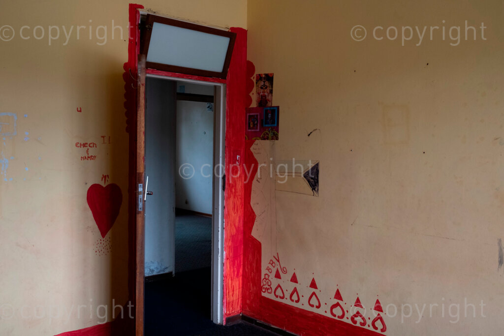 The building on 2 Abattoir Road in Pietermaritzburg, South Africa is like many places in the city, in that it has a past. When it was first built, it was the bus depot for the city’s segregated transport department. It was also the Tabitha Ministries home for some of Pietermaritzburg’s HIV/AIDS infected children. After this it was the home of the Christian Life Academy school and also a safe space during the COVID pandemic.

2 Abattoir Road has now been cleared out to make a safe place and shelter by the PMB Homeless Network for the homeless people on the streets of the same city.

These pictures were taken during a two week period while the building was being cleared out in preparation for it’s new purposing. 

During that period of clearing out, the remnants of the past uses of 2 Abattoir Road and elements from the times in which this building has been in use have been juxtaposed and gathered. These ephemeral moments have been caught by the eye of the photographer; all before all these elements moved on, thrown away or painted over in the readying for its new use as a safe space and shelter for the city’s homeless people. 

This body of work is a visual documentation of aspects of the history of 2 Abattoir Road, Pietermaritzburg, South Africa, a space that was. 2023, Pietermaritzburg, South Africa.
