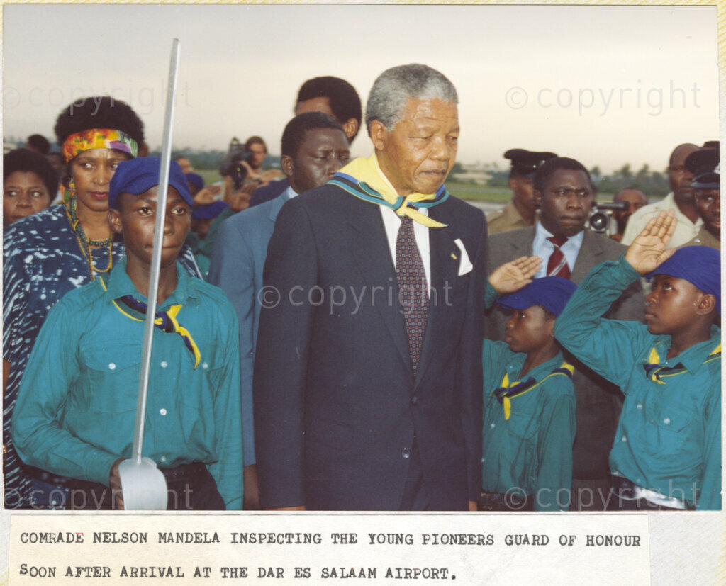 Dar Es Salaam, Tanzania. PHOTO: ANC Archives. 6 March 1990. Nelson Mandela (centre front), recently released from prison, inspecting the Young Pioneer's guard of honor soon after the arrival of the Mandelas at Dar Es Salaam International Airport, in Tanzania. Nelson and Winnie Mandela (left, wearing a head band), are on a tour of African states which support the liberation struggle in South Africa.