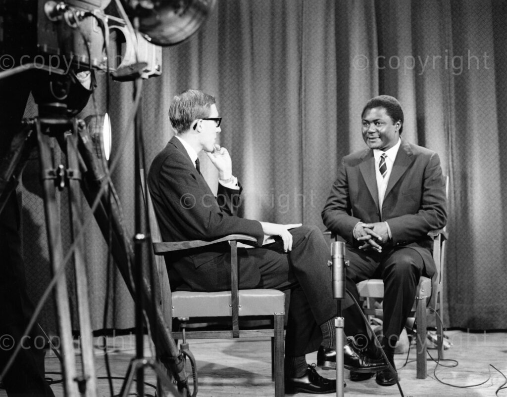 In 1964, Tom Mboya gave an interview during his visit to Australia, where he was a prominent Kenyan politician and labor leader. In the interview, Mboya discussed various topics, including the political climate in Kenya, the challenges of nation-building in the post-colonial era, and his views on Pan-Africanism and African unity. Mboya emphasized the importance of education and economic development as crucial factors for the progress of African nations. He also spoke about Kenya's efforts to balance relationships with both the West and the East during the Cold War, striving to maintain a non-aligned stance while seeking support for Kenya's development goals. The interview highlighted Mboya's charisma and intellect, reflecting his influential role in shaping Kenya's path as a newly independent nation. His vision for Africa, focused on self-reliance, unity, and progress, resonated with many during a time of significant change across the continent.