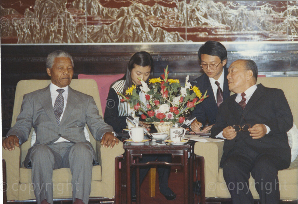 The Great Hall of the People, Beijing, Beijing Municipality, People's Republic of China , 19921005. PHOTO: ANC Archives.


The President of the African National Congress, Nelson Mandela, accompanied by the ANC spokesman, Mr Pallo Jordan, visits the People's Republic of China (PRC) in October 1992. At this time South Africa recognises Taiwan (ROC) as independent from the PRC, and Nelson Mandela is in support of a 'Two Chinas' policy. The weeklong visit to China involves discussions towards establishing official ties between a Greater China (including PRC and ROC) and South Africa. President Yang Shangkun (right) and the Chinese Communist Party General Secretary, Jiang Zemin, greet Mr Mandela (left) at a welcoming ceremony at the Great Hall of the People in Beijing on the 5 October 1993. After many years of strong lobbying by the PRC, and engagement with Nelson Mandela, official relations between the PRC's 'One China' and South Africa were established in 1998.