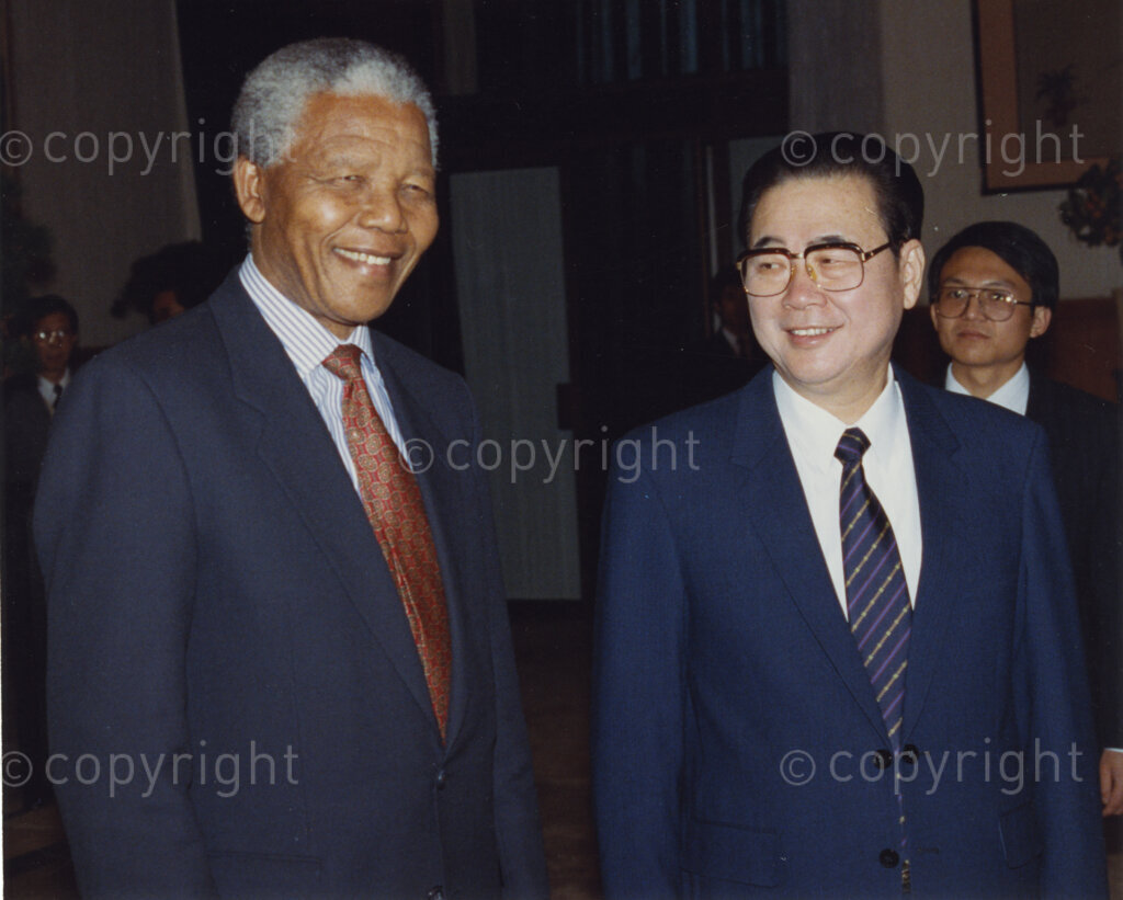 The Great Hall of the People , Beijing, Beijing Municipality, People's Republic of China , 19921006. PHOTO: ANC Archives.

The President of the African National Congress, Nelson Mandela, accompanied by the ANC spokesman, Mr Pallo Jordan, visits the People's Republic of China (PRC) in October 1992. The weeklong visit to China involves discussions towards establishing official ties between a Greater China (including PRC and the Republic of China) and South Africa. A number of welcoming ceremonies are held at which the ANC delegates meet with Chinese dignitaries including President Yang Shangkun and the Chinese Communist Party General Secretary, Jiang Zemin. On the 6 October, Nelson Mandela (left) meets with Prime Minister Li Peng (right) at a welcoming ceremony at the Great Hall of the People in Beijing. On the same day, Nelson Mandela visits Peking University where he is awarded an honorary doctorate by the university's Vice President and professor of law, Professor Luo Haocai. (After many years of strong lobbying by the PRC, and engagement with Nelson Mandela, official relations between the PRC's 'One China' and South Africa were established in 1998.)