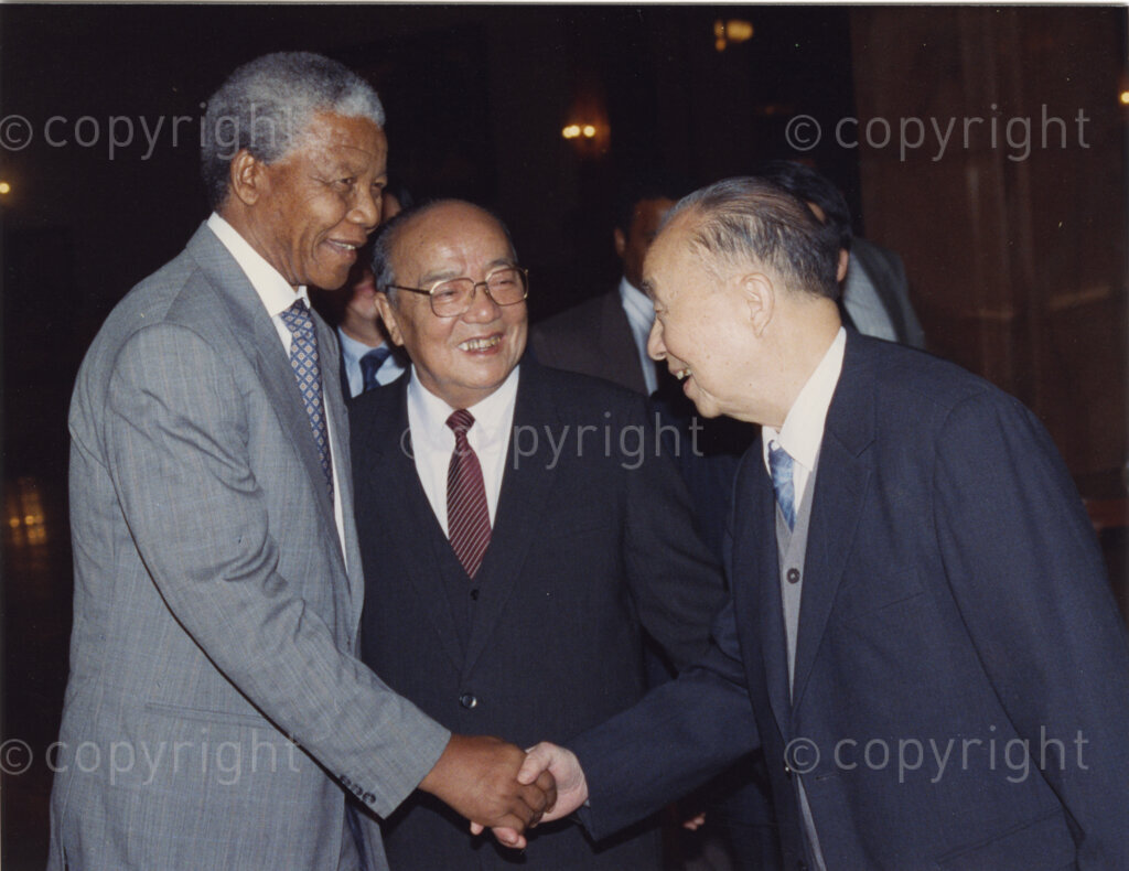 Great Hall of the People, Beijing, Beijing Municipality, People's Republic of China , 19921005. PHOTO: ANC Archives.

The President of the African National Congress, Nelson Mandela, accompanied by the ANC spokesman, Mr Pallo Jordan, visits the People's Republic of China (PRC) in October 1992. At this time South Africa recognises Taiwan (ROC) as independent from the PRC, and Nelson Mandela is in support of a 'Two Chinas' policy. The weeklong visit to China involves discussions towards establishing official ties between a Greater China (including PRC and ROC) and South Africa. President Yang Shangkun (centre) and the Chinese Communist Party General Secretary, Jiang Zemin, greet Mr Mandela (left) at a welcoming ceremony at the Great Hall of the People in Beijing on the 5 October 1993. After many years of strong lobbying by the PRC, and engagement with Nelson Mandela, official relations between the PRC's 'One China' and South Africa were established in 1998.