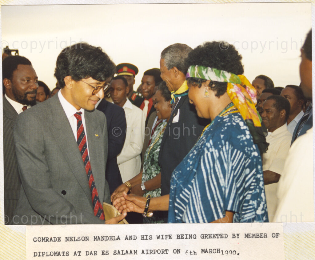 Dar Es Salaam, Tanzania. PHOTO: ANC Archives. 6 March 1990. Winnie Mandela (right), and her husband and Deputy President of the African National Congress (ANC), Nelson Mandela, (beside her), are welcomed to Dar Es Salaam International Airport, in Tanzania, by unidentified officials and diplomats. The Mandelas are on the first leg of a tour of African states which support the liberation struggle in South Africa. It is just one month since Nelson Mandela was released from prison.