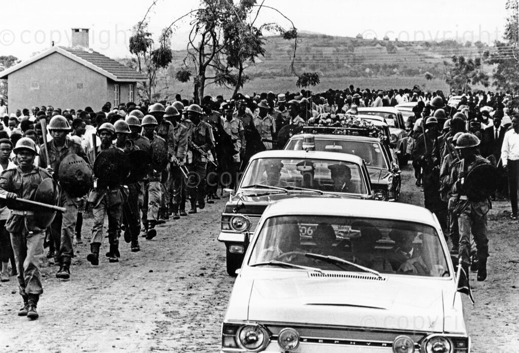 Tom Mboya's cortège reaches Rusinga Island, marking the final leg of his journey home. Thousands of mourners gathered to pay their respects to the fallen statesman, whose assassination shook the nation. The solemn procession winds through the island, a poignant tribute to Mboya's lasting legacy in Kenya's history.