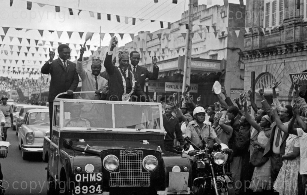The iconic image of Jomo Kenyatta, Tom Mboya, Jaramogi Oginga Odinga, and James Gichuru waving at a crowd from a car in 1963 symbolizes the unity and triumph of Kenya's independence movement. As key leaders, Kenyatta, the nation's first Prime Minister and later President, Mboya, a prominent trade unionist and politician, Odinga, the first Vice President and advocate for African socialism, and Gichuru, a founding member of KANU and influential political figure, their collective presence underscored the collaborative effort and shared vision that were instrumental in achieving Kenya's freedom from British colonial rule.