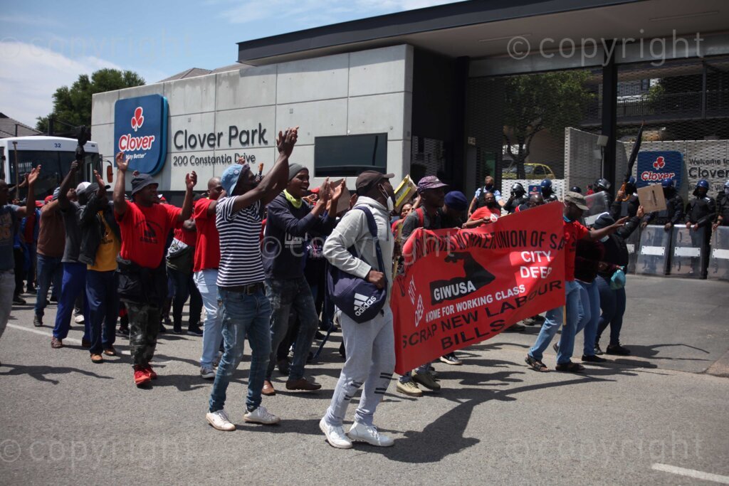 Members of Food and Allied Workers Union (FAWU) and General Industries Workers Union of South Africa (GIWUSA) together with members of civil society demonstrating at the Clover SA head offices at Constantia Kloof, Rooderkop in the east of Johannesburg, Gauteng in South Africa as the strike intensified. In 2019, Clover was bought by MILCO Consortium from Israel's top manufacturer and distributor of beverages, Central Bottling Company.  02/12/2021 Photo: Oupa Nkosi