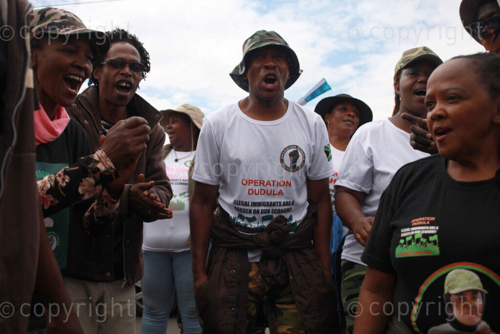 Operation Dudula members singing struggle songs outside on the streets during the funeral service of Kgomotso Diale held at Pimville Community Centre in Soweto, Johannesburg in Gauteng, South Africa. 23/04/2022 Photo: Oupa Nkosi 