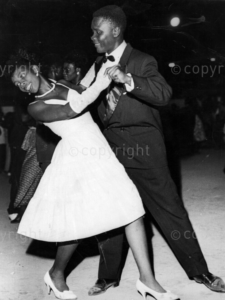 Ghana Learns To Dance – Tangoing twosome, they wanted a gay evening, so they dressed up to the nines, took a taxi to a night club and here they are, on the floor, letting themselves go to the exciting music of a happy tango. Foxtrot, tango, waltz, cha cha cha, rock n' roll; it does not matter what is the dance, or whether it is simple or complicated, you can be pretty certain that somewhere in Accra someone is trying to learn the steps. Yes, ballroom dancing is the craze, and everyone's in the swing. If you pop in at any of Accra's night clubs in the early evening, before the real show show of the night comes on, you will find scores of people on the open floor going through a series of amazing movements. And you will find they are learning to dance.