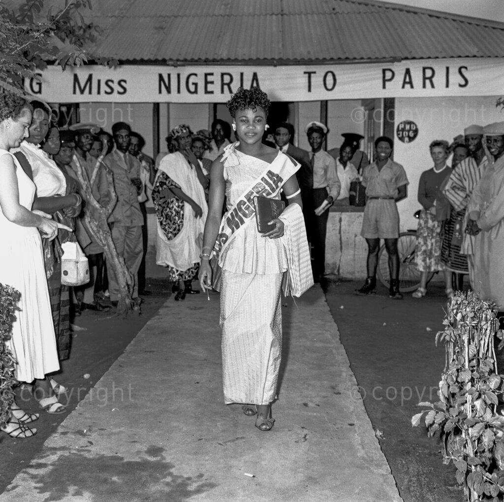 How Does It feels To Be Miss Nigeria? Oh, it’s quite a job to be popular. It gives one dizziness, and it’s only the realisation that one is on top by the peoples choice that gives one the courage to go through it without succumbing. So said Miss Nigeria 1958. And who is Miss Nigeria this embodiment of a delicious sensation? She is a 19- year-old Helen Anyamaeluna. And before her day of glory, she was a clerk in the Eastern Nigeria Ministry of Transport. Helen is no brainless beauty. She is a linguist who can hold her own in English, French, Ibo, Efik and Yoruba.
