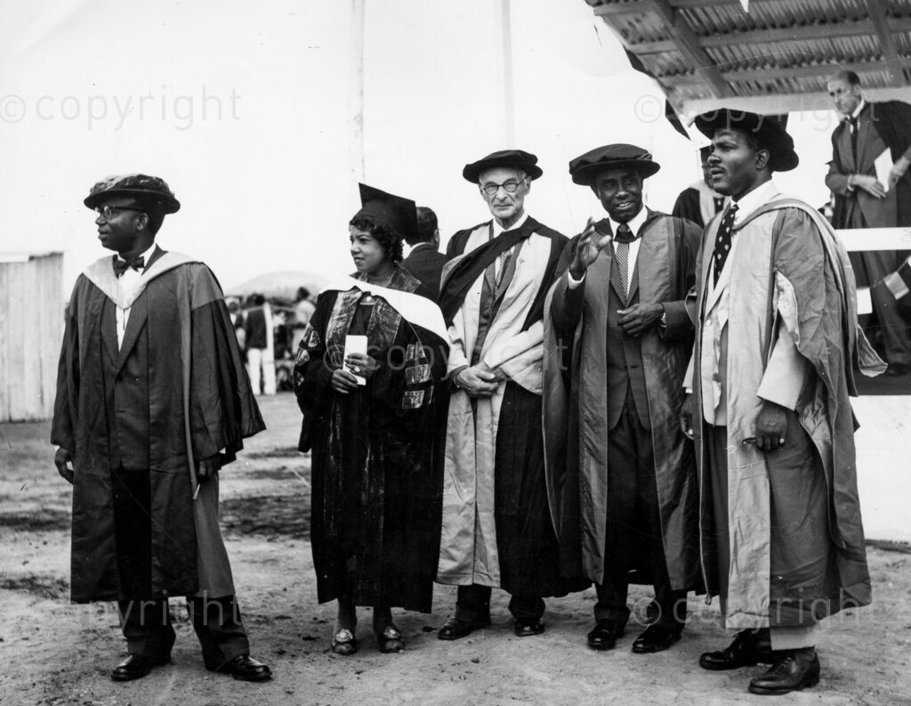 Zik's University; How he came to choose Nsukka. Watching the opening, Professor Dike, Principal of the University College, Ibadan, watches with other professors the opening, last October, of the University of Nigeria. A faithful telephone operator brought Dr Azikiwe a message that made him think his life was in danger. Zik fled from Lagos on the same night, and went into hiding in Nsukka. The sequence of events led to Nsukka becoming a university city.