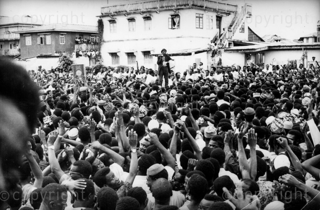 The Big Strike; All hands are raised as workers vote to continue the strike. Man on the platform: Michael Imoude, whose sway of the crowd set the pace of the strike. Could the general strike of May 31 to June 13 have been averted if the governments of the Nigerian Federation, on the one hand, and the Joint Action Committee, on the other, had exercised more self control, more ability to give and take, more mutual trust, less arrogance, less jealousy and less delight in the show of will power and strength?