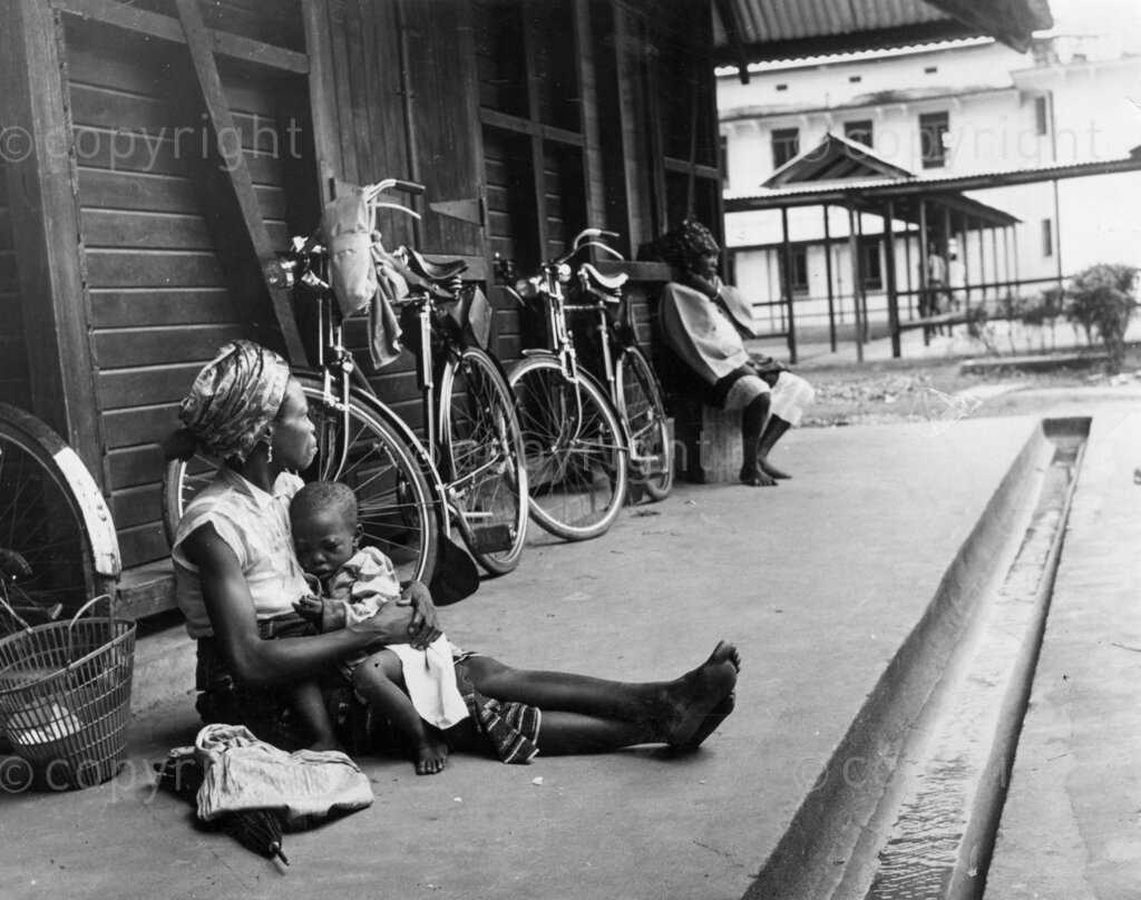 It's tough being sick in Nigeria if your are poor. Some patients beg for money to pay medical fees. Two women sit outside the entrance of medical building begging for money to pay for their treatment. The woman on the left has brought her child, but without cash the child is unlikely to be treated. 