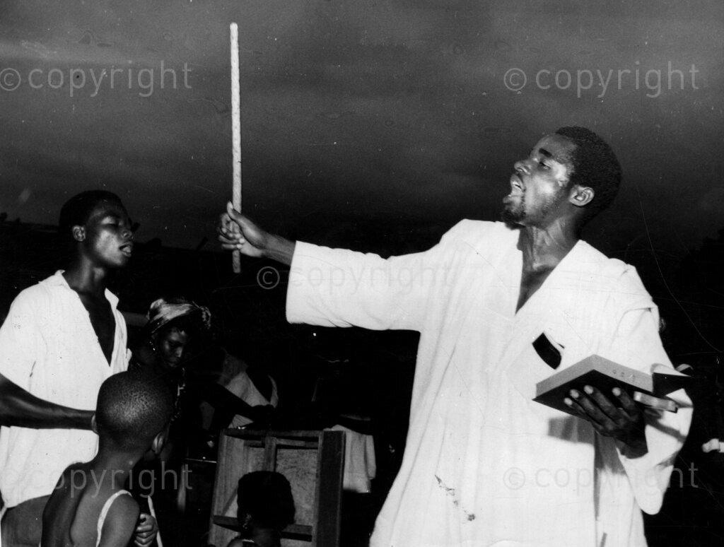 Praise the Lord! Leader of church with a stick.