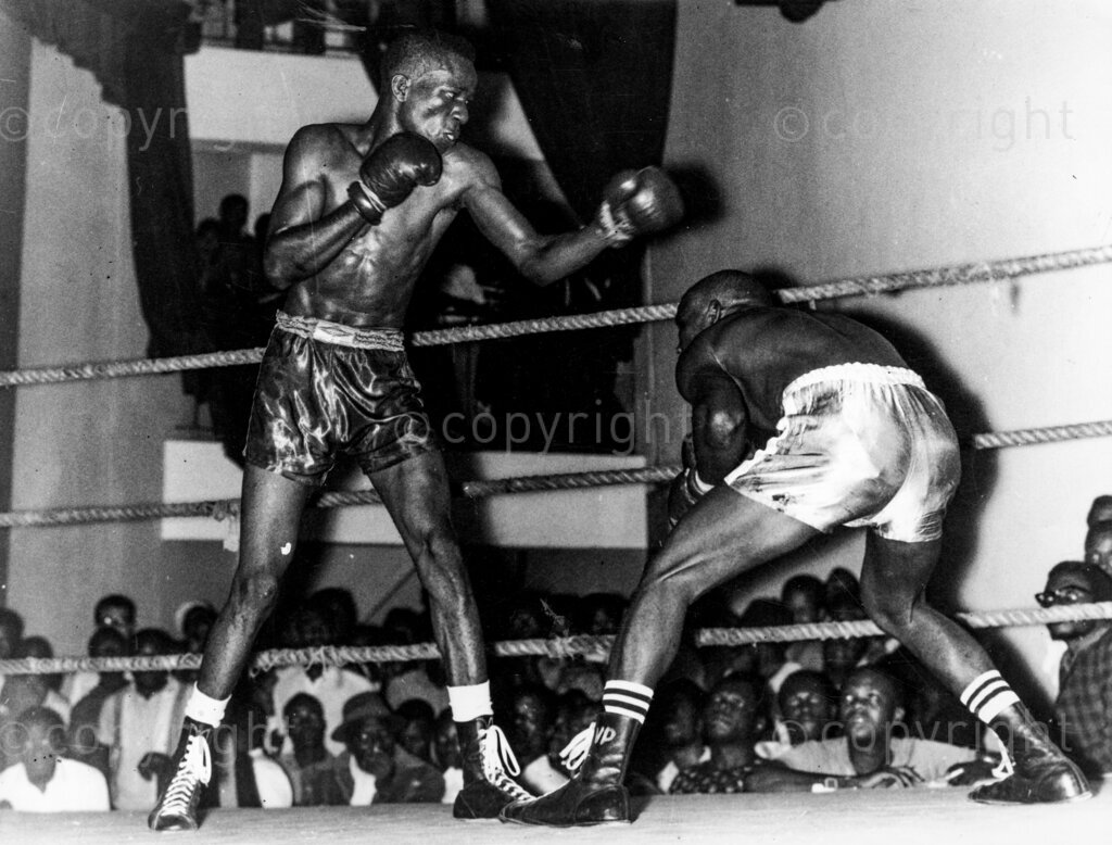 Victory's Victor. Victor Paul vs Love Muka. A typical incident from the fight. Love Muka (left) looks apprehensive as Victor Paul weaves for an opening to attack. He deserves that title too! Nigerian featherweight boxers. Victor Paul in his smashing win over the game champion Love Muka, he has proved his point and punctuated the argument with round blobs of flying leather.