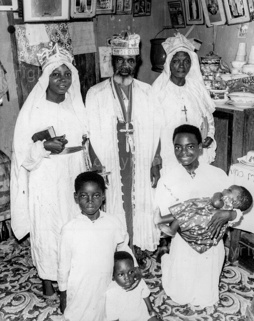 The Prophet Who Told Us So – Prophet Otubogunwa poses for a photograph with his two wives and four of his children. Prophet Baba Aladura Otubogunwa, a prophet of the Cherubim and Seraphim Church at Mushin, near Lagos, announced a fearsome vision during which God revealed to him the many calamities that He would unleash upon the Federation of Nigeria – beginning from the second quarter of the year – unless her people repented and took to praying hard for forgiveness.