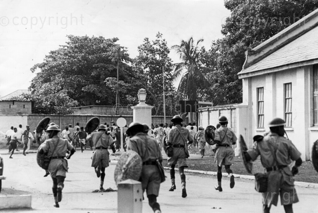 That Lagos Railway Riot. Shields raised, batons swinging, they charged crowd. The workers were not permitted to make for their destination. Baton-happy policemen charged them, hitting indiscriminately. It was tense, ugly there while it lasted. Men fell bleeding and groaning to ground. More defiant the rioters, tougher police became. Later, the rioters dispersed. In Lagos railwaymen protested because certain high ranking job was not given to a Nigerian. They tried to get a note to the white boss whom they wanted to resign. The police charged with batons.