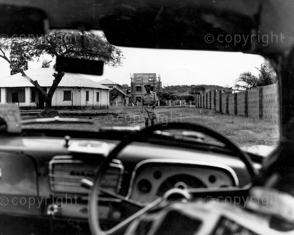 Zik's University; How he came to choose Nsukka. The confrontation, protected from everybody, Dr Azikiwe's famous cottage at Nsukka can be seen but not approached. Here a Drum reporter is being barred from entering by a frowning officer of the law. A faithful telephone operator brought Dr Azikiwe a message that made him think his life was in danger. Zik fled from Lagos on the same night, and went into hiding in Nsukka. The sequence of events led to Nsukka becoming university city.