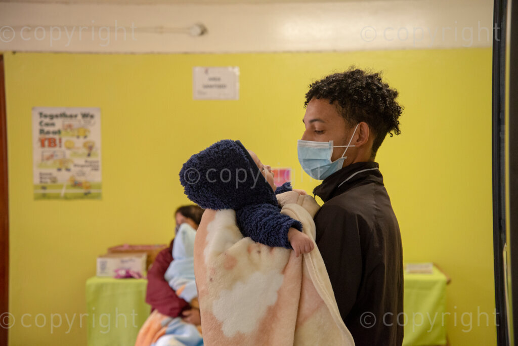 A staff member holds a baby for a mother, as The City of Cape Town opened a clinic extension in the Elsies River Library, to serve mothers and children with routine visits such as family planning and immunizations, today, Monday, July 13, 2020. Clinic extensions are being constructed to separate COVID-19 treatment and diagnosis from other treatments. PHOTO: EVA-LOTTA JANSSON 