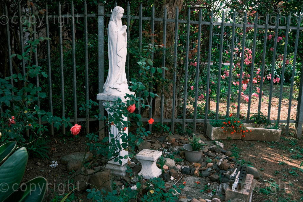 Figures in a 'Scape, shrine to St Mary in the garden of St Mary’s Catholic Church, the church is just over the road to Allard House where the French Prince Imperial lay in state after he was killed in a battle against the Zulu nation while fighting for the British forces in the Anglo Zulu war. Nov. 2024, Pietermaritzburg, South Africa.