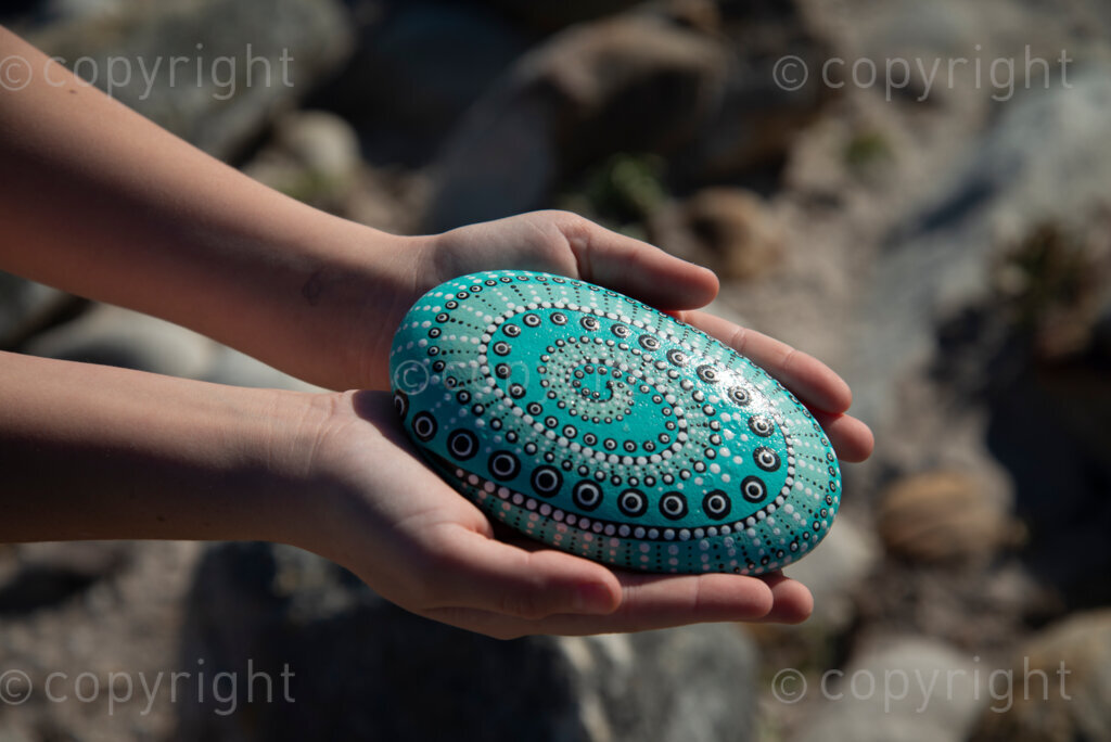Rock artist Lara Thompson's daugther Shae, 12, demonstrates how they hide her mother's rocks for people to find near Slangkop light house in Kommetjie, Cape Town, Thursday, July 17, 2020. Here Shae holds a large rock her mother painted with a Mandala. PHOTO: EVA-LOTTA JANSSON 