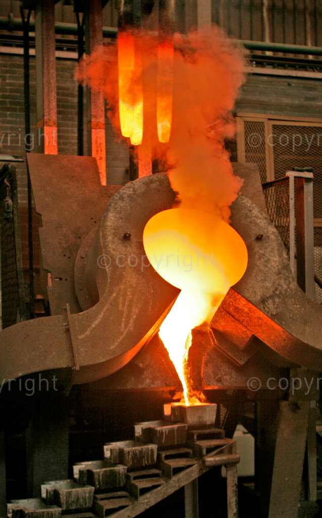 Gold being poured into ingot moulds after being heated and melted in furnace.